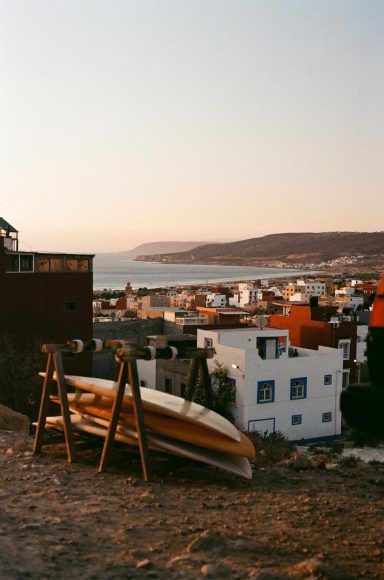 Analog photography of Morocco coastal town at sunset with surfboards, by artist Eline van Velsen